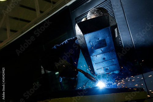 Saldatore al lavoro protetto da una maschera speciale photo