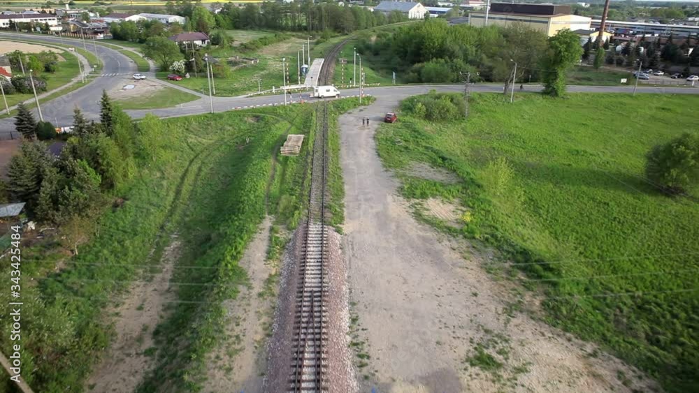 Lines of railway tracks with train cars, and a road with a passing car Lines of railway tracks with train cars, and a road with a passing car