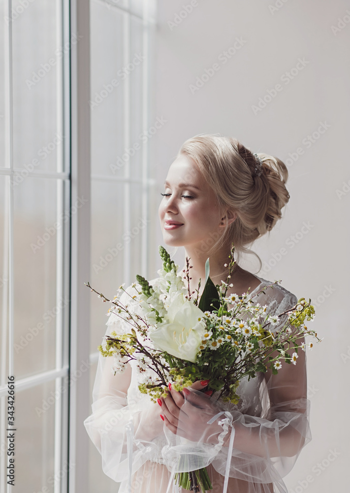 Romantic bride with wedding bouquet near window waiting groom Romantic bride with wedding bouquet near window waiting groom
