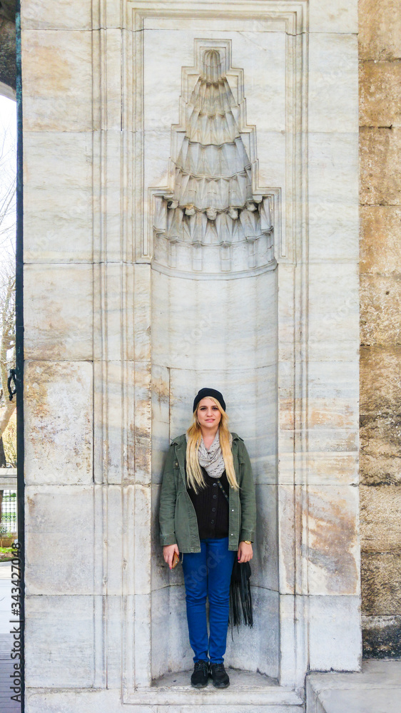Caucasian woman standing in wall facade. Sultan Ahmet / Blue Mosque, Istanbul, Turkey