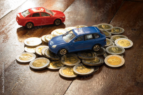 Small blue cars on gold money coins.