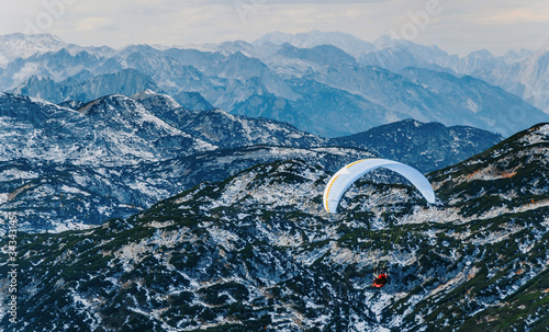 Beautiful mountain view with paraglider near Hallstatt village, Austria. Paragliding and parashuting in Alps. Beautiful perspective view of rocks range.