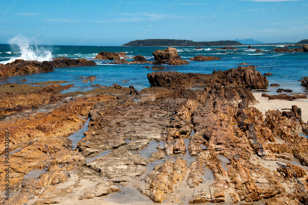 Tomakin Australia, view of rock outcrop  looking out to sea with island on the horizon