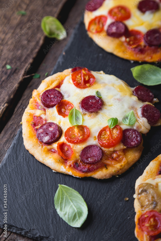 Homemade mini pizza with mushrooms, cheese and sausages