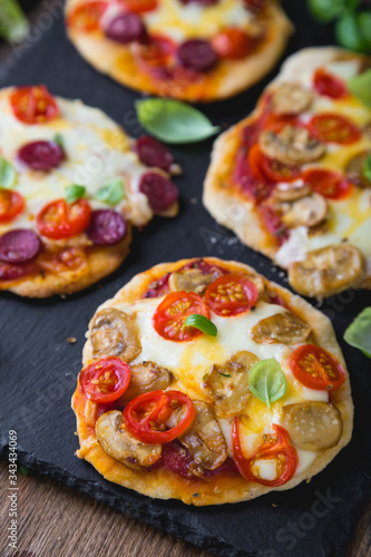 Homemade mini pizza with mushrooms, cheese and sausages