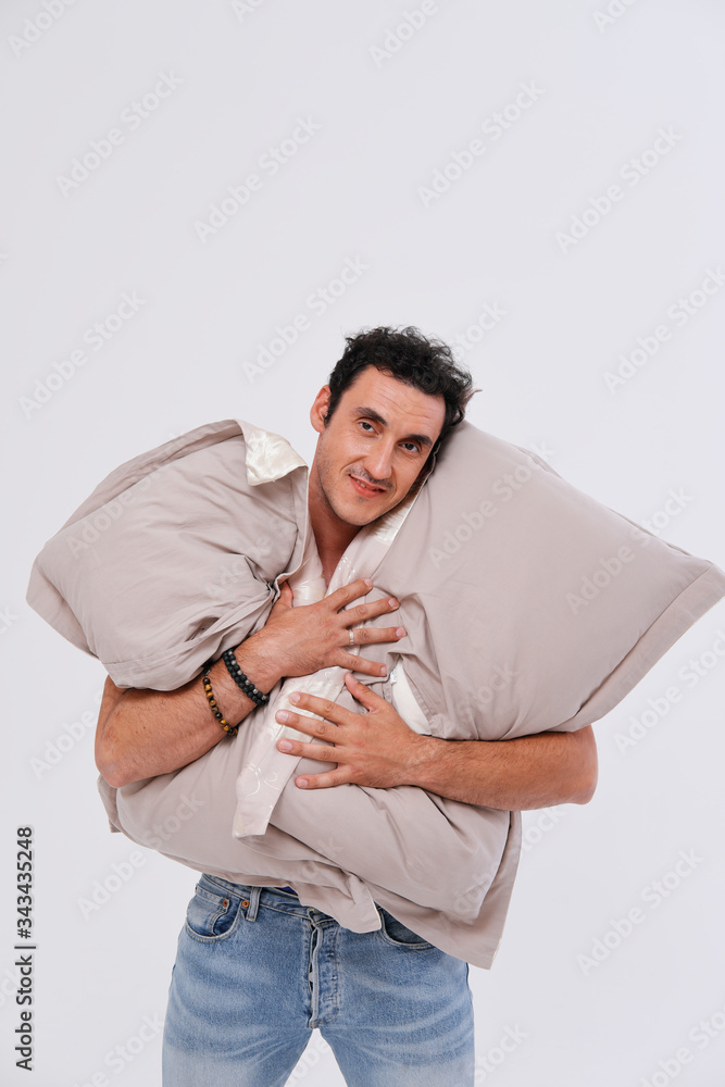 Studio portrait of sleepy man holding pillows Studio portrait of sleepy man holding pillows