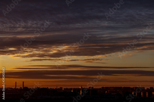 Beautiful colorful sunset over the city horizon. Magnificent clouds over the contours of buildings. Place for your signature. You can use it for business cards, flyers, and backgrounds. © Alex Vog