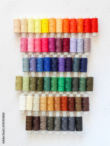 Colorful threads lined up neatly on a white background