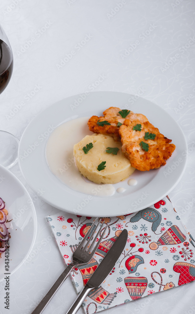 
dinner menu, feast and chicken cutlet with salad and red wine in combination with a tablecloth, tableware on the table