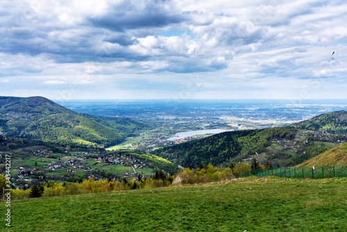 Fototapeta Naklejka Na Ścianę i Meble -  Aerial view of Miedzybrodzie town in Beskid Maly mountain range. Lake and dam in the background. Beautiful spring panorama.