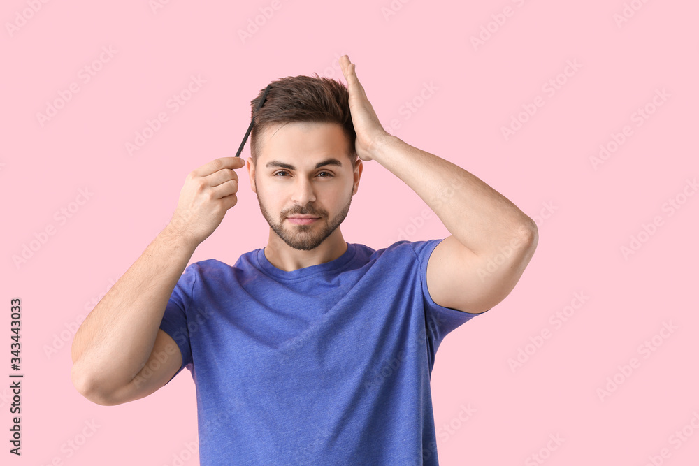 Handsome young man with comb on color background Handsome young man with comb on color background