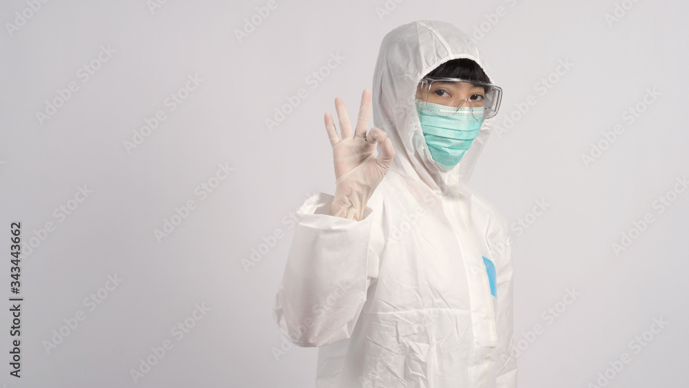 Middle aged asian nurse woman wearing PPE body suit or personal protective equipment which for use in pandemic virus infected situation with medical mask, gloves, goggles