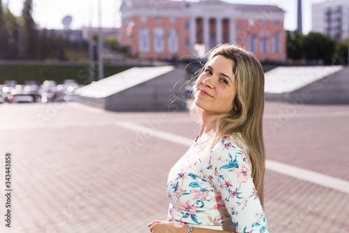 Pretty blonde woman smiling in the park. Summer, holidays and vacation concept. © satura_