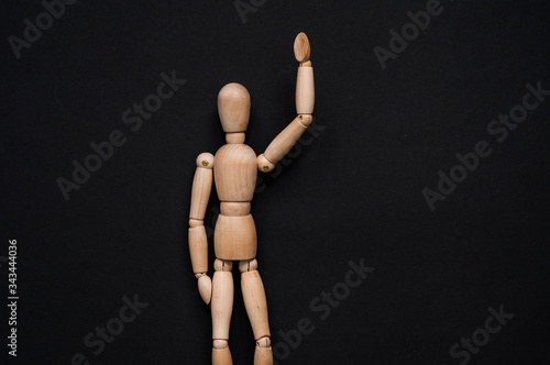 Wooden dummy with hands on hips on grey backgroundToilet paper and wooden man on yellow background, space for text