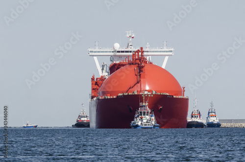 LNG TANKER - The beautiful red ship flows to the gas terminal unloading quay
