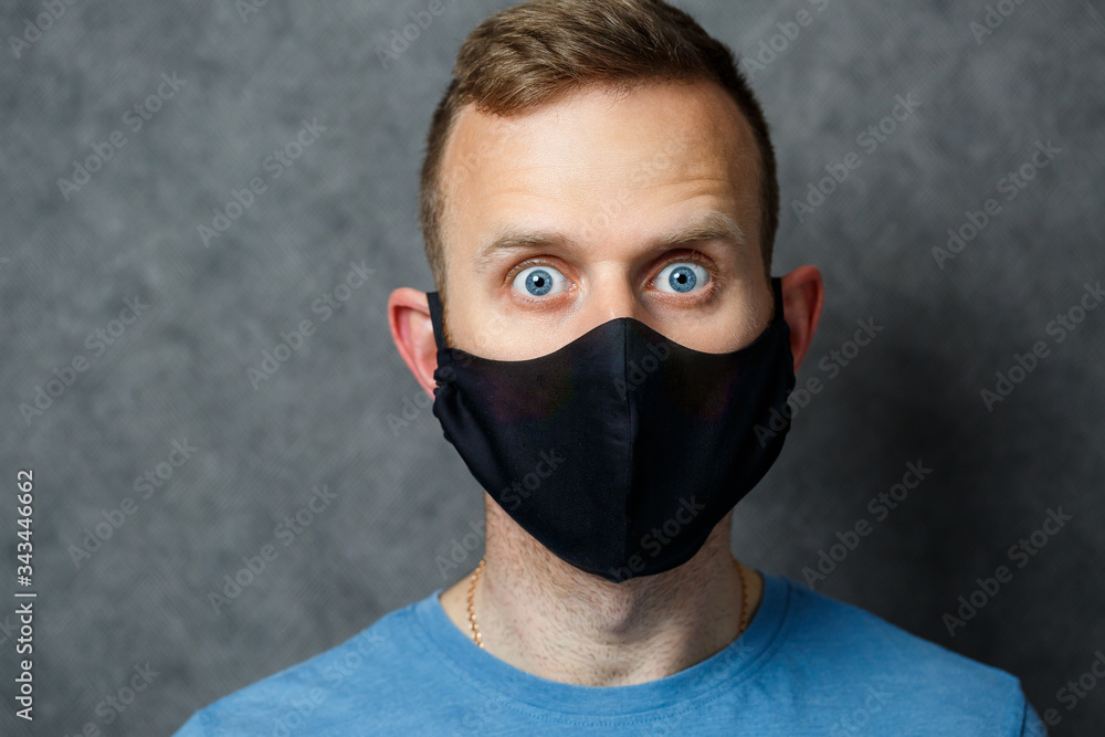 young guy man in black protective medical mask against viruses. COVID 19 young guy man in black protective medical mask against viruses. COVID 19