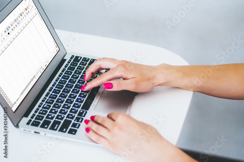 Female hands working on modern laptop. Office desktop on white background. Close-up partial view of woman holding credit card and using laptop at home