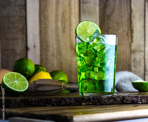 Refreshing green cocktail with lime and lemon on a wooden table