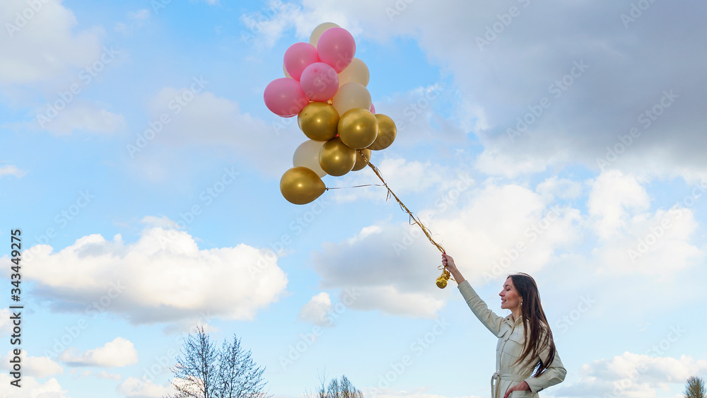 Happy young woman holding colorful balloons on the classic blue sky background. Celebration concept. Space for text. Happy young woman holding colorful balloons on the classic blue sky background. Celebration concept. Space for text.