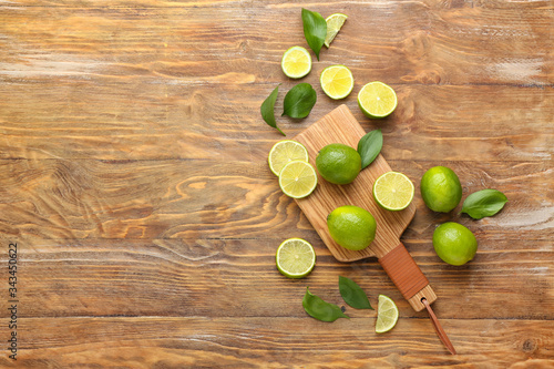 Fresh limes with board on wooden background