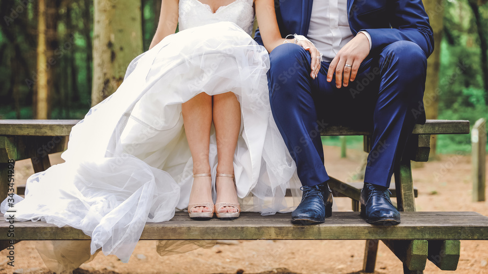 Ambiance Mariage, amour en foret. Mariés assis sur un banc en bois. Robe  blanche, costume bleu, jambes, pieds et chaussures de mariage. Photos |  Adobe Stock