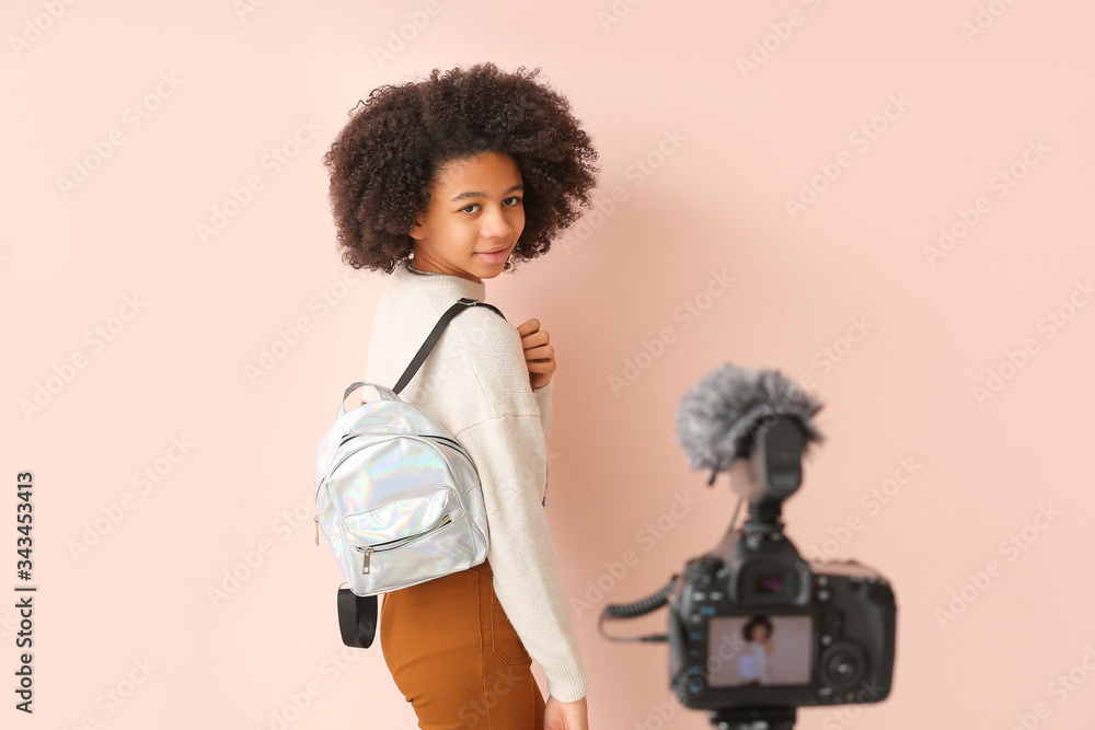 African-American teenage fashion blogger recording video on color background African-American teenage fashion blogger recording video on color background