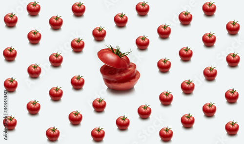 One large sliced tomato on the background of many tomatoes