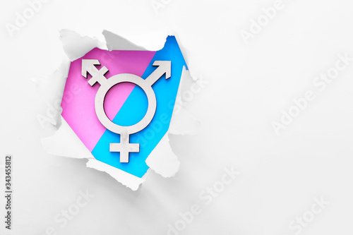 Symbol of transgender visible through torn paper on color background photo
