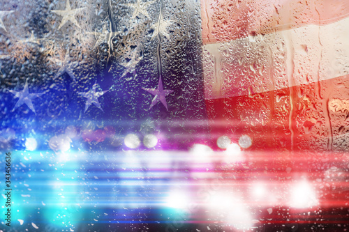 Double exposure of American flag and police cars on street at night