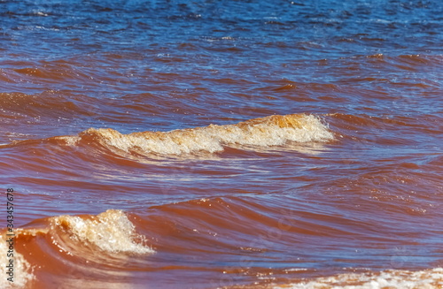 Waves on the surface of the river, red from dissolved clay (Background, banner, Wallpaper)