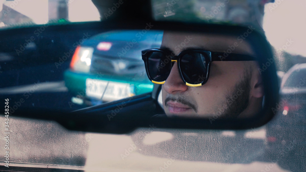 young man in sunglasses driving car