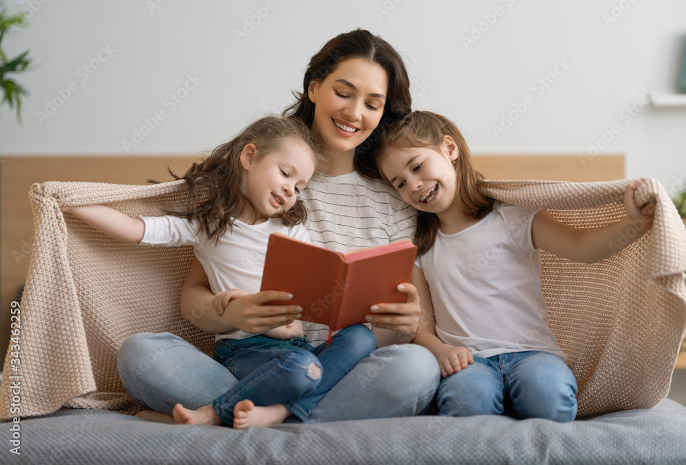 mother reading a book to her daughters mother reading a book to her daughters