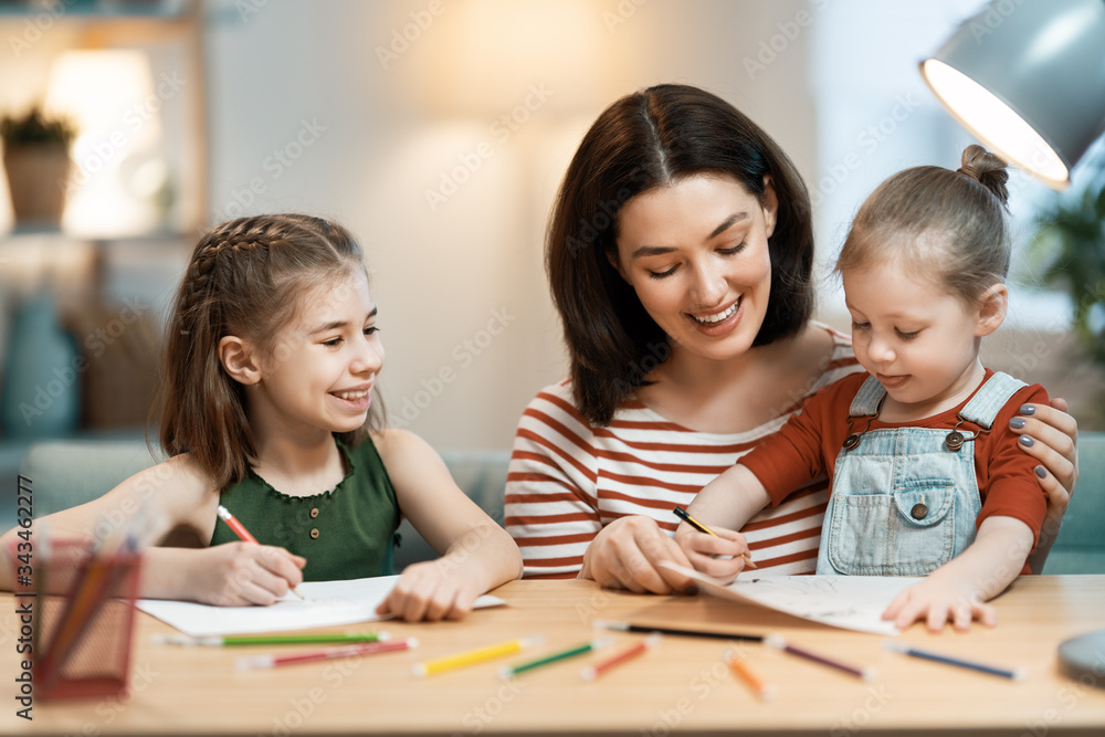 Mother and daughters are drawing together Mother and daughters are drawing together