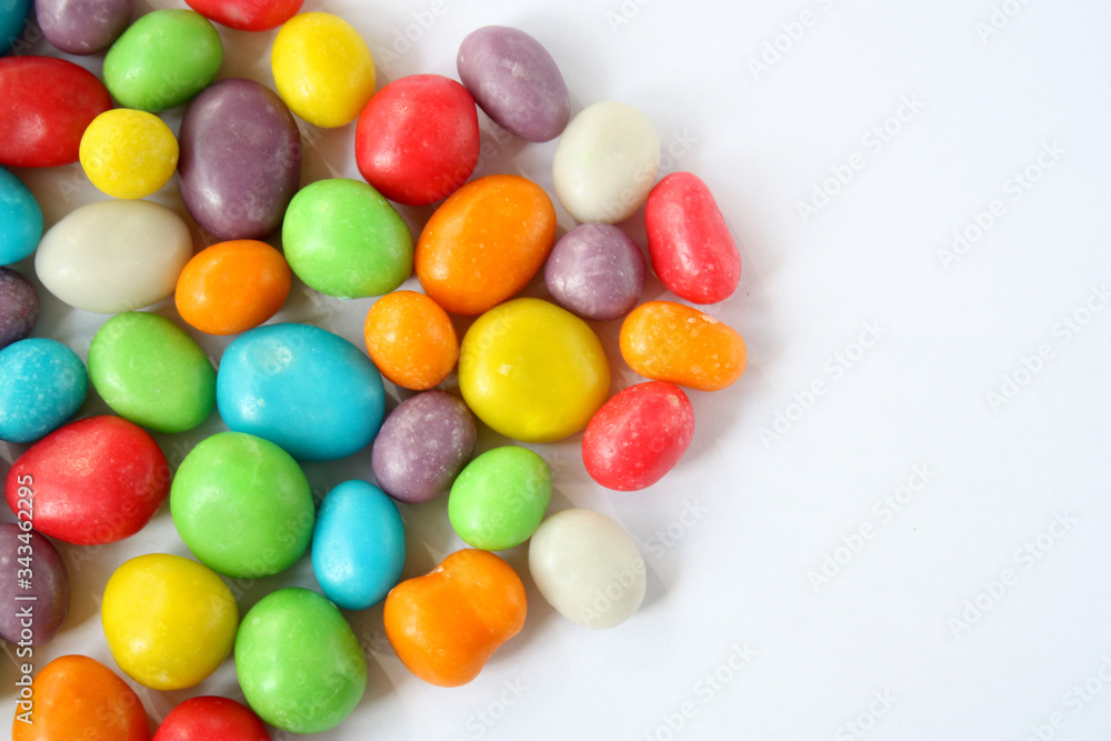 Multi-colored dragees, sweet candies in the glaze. The atmosphere of the holiday. Raisins in a sweet bright shell. Multi-colored dragees, sweet candies in the glaze. The atmosphere of the holiday. Raisins in a sweet bright shell.
