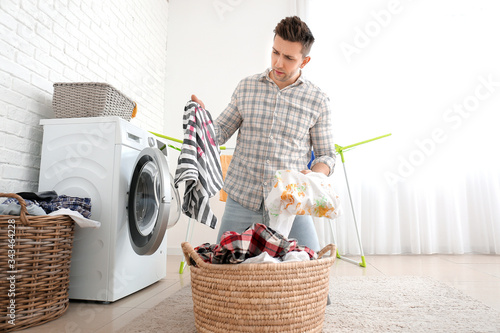 Troubled man doing laundry ...