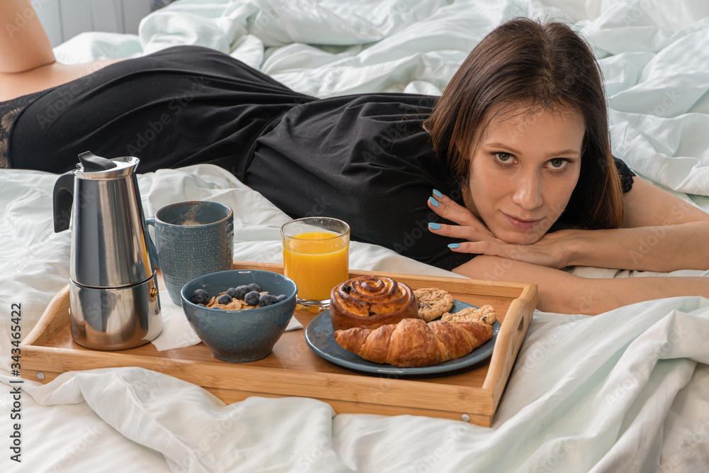 Happy young beautiful woman have breakfast in bed