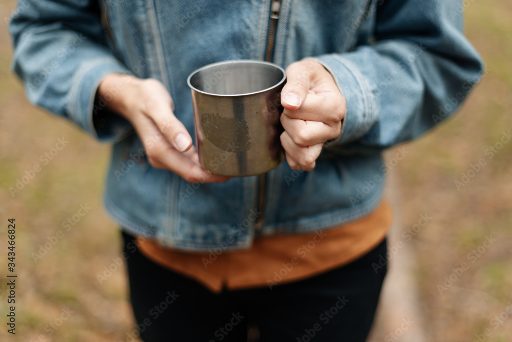 Girl with an iron cup of tea in the woods Girl with an iron cup of tea in the woods