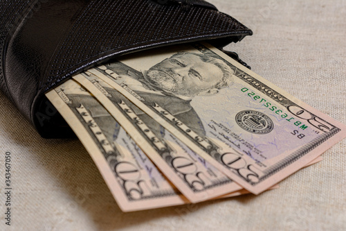 Black wallet with dollars 50 on a gray background. photo