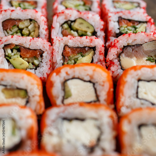 Closeup of sushi roll with salmon, avocado and cheese. Japanese cuisine restaurant.