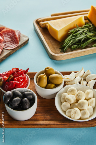 High angle view of boards with antipasto ingredients on blue background