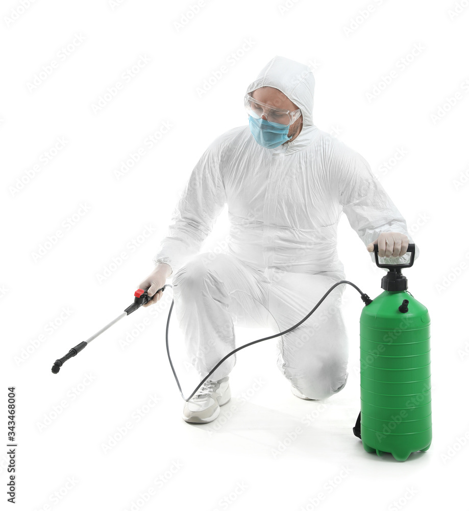 Worker in biohazard suit and with disinfectant on white background