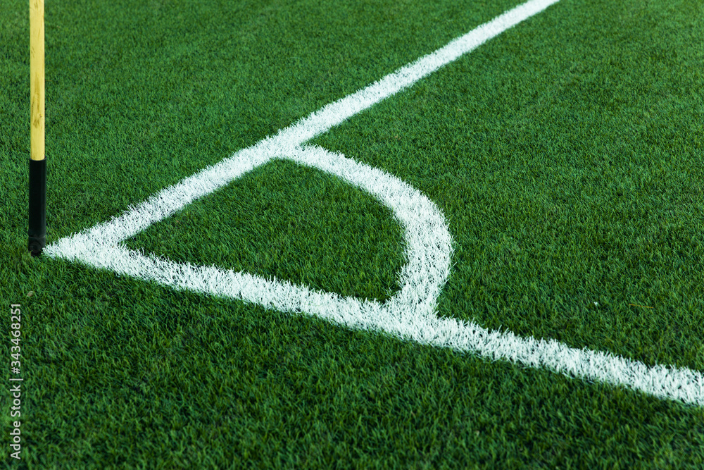 Football field corner with white marks and flag