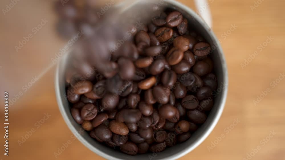 Put coffee beans into the coffee grinder. In the frame of an coffee grinder, in which freshly roasted coffee beans fall asleep Put coffee beans into the coffee grinder. In the frame of an coffee grinder, in which freshly roasted coffee beans fall asleep