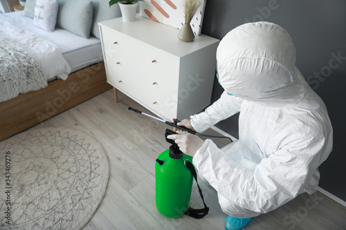 Worker in biohazard suit di...