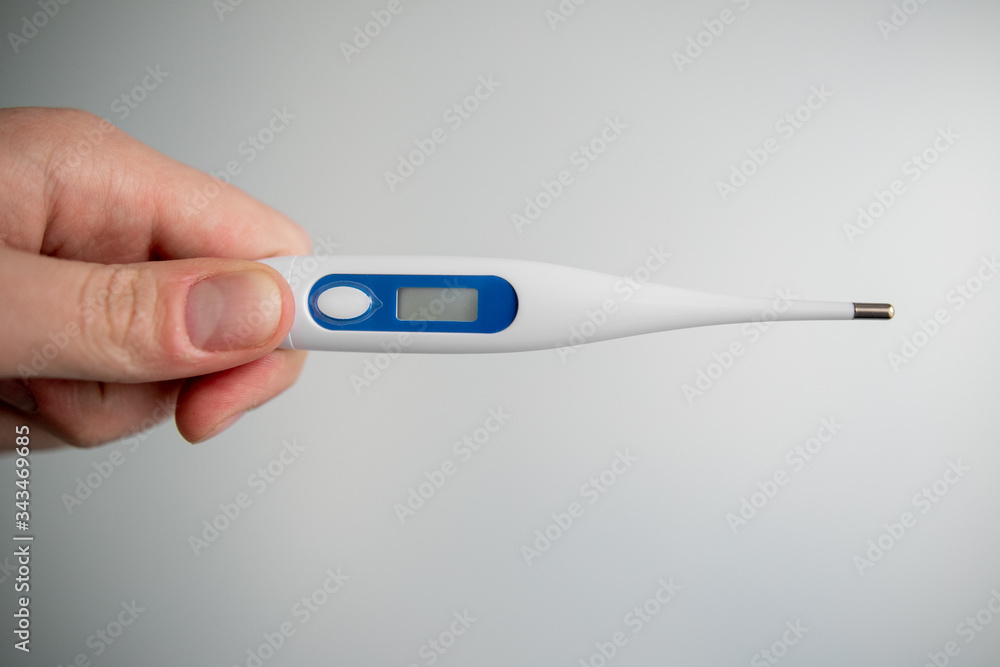 Obraz premium man holds a medical thermometer in his hand