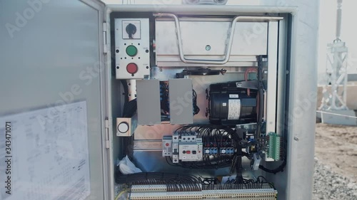 Switchboard with mounted electrical equipment in the territory of a power substation. The smooth movement of the camera from top to bottom.
