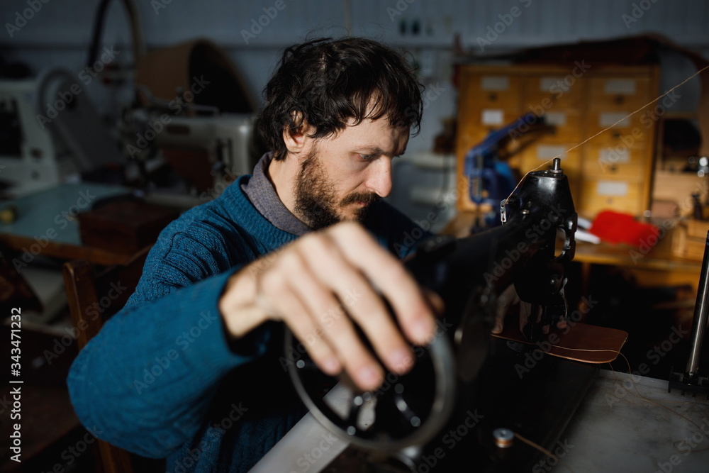 A leather craftsman works in a workshop. A leather craftsman works in a workshop.
