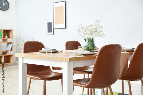 Served table in modern dining room © Pixel-Shot