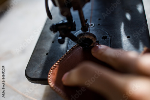 A leather craftsman works in a workshop. 