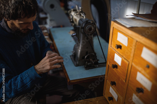 A leather craftsman works in a workshop. 